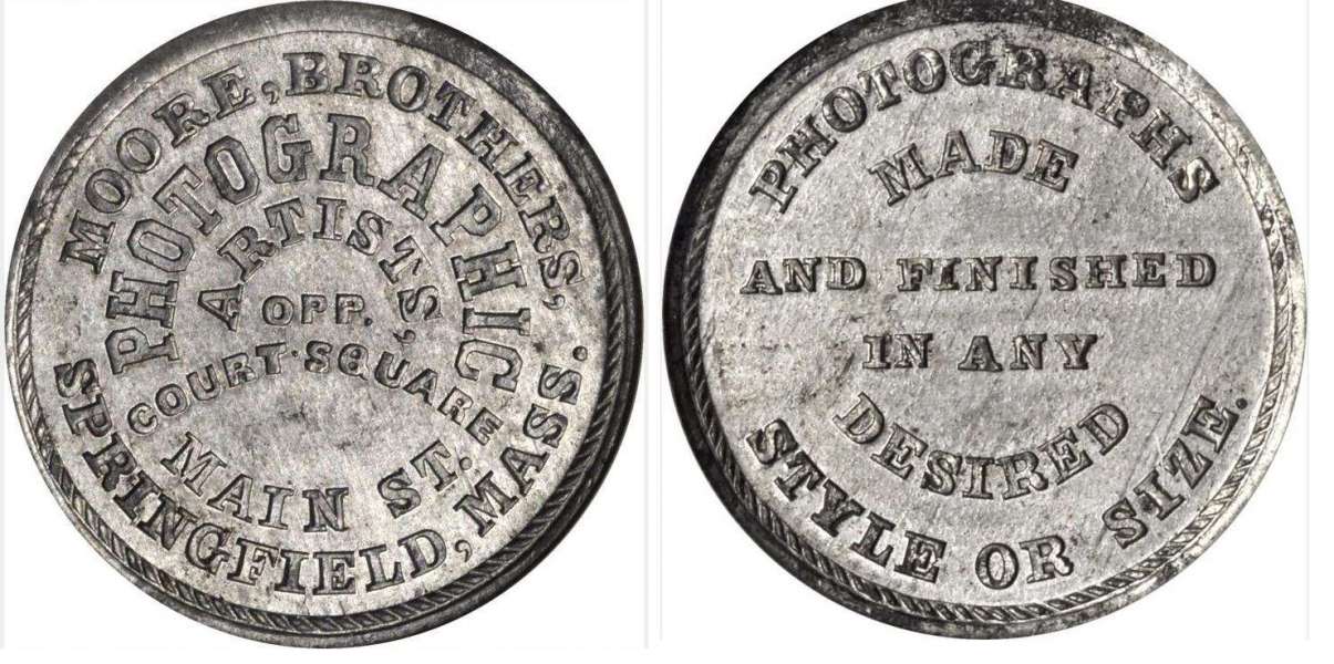 JAB-21 MOORE BROTHERS PHOTOGRAPHY Tin #3
28mm -  400 struck

Dies were cut in 1865 and presumably given to the Moore Brothers.  They are currently unaccounted for.

The Moore Brothers were jointly in Business at 441 Main Street in Springfield, Mass. from 1859 through 1877.  During the Civil War, they photographed every new recruit from Springfield and provided copies at no charge.  Between the two Brothers, they amassed more than 80,000 negatives.

The metalic composition of this piece appears to be different than that of the first example pictured.  I question whether there may have been more than one striking for the merchant?  

Although it is accepted that there were 400 pieces struck in Tin, the piece is much rarely than the mintage would indicate.  A silvered edge lettered example sold for $550 in a Hayden 8/2015 Sale.  A NGC-63 example sold for $264 in the 9/2021 Stacks sale, lot 70119.
